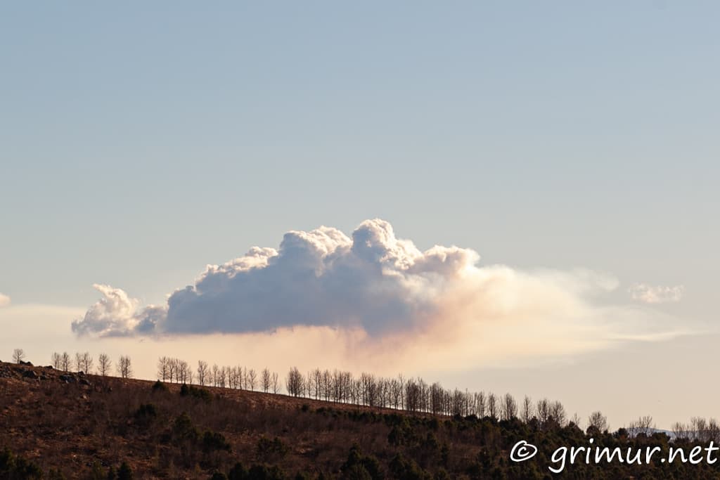 Volcano cloud in a distance and a sunset